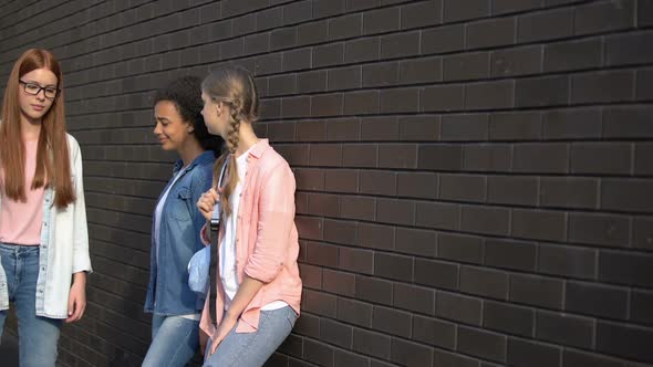 Shy High School Student Passing by Mocking Teenagers Leaning Wall in Backyard