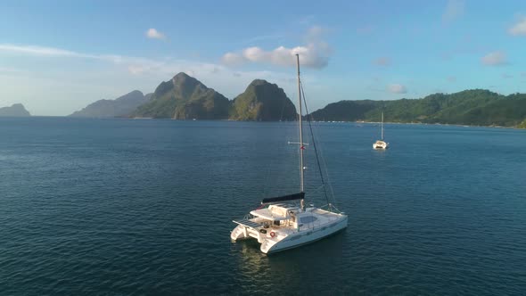 Aerial Drone View of Sailing Yacht Anchored in the Bay with Clear and Turquoise Water on the Sunset