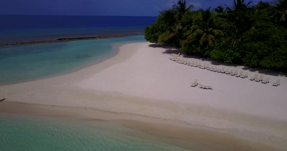 Wide angle drone tourism shot of a paradise sunny white sand beach and aqua blue water background 