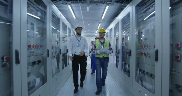 Electrical Workers Walking in the Control Room