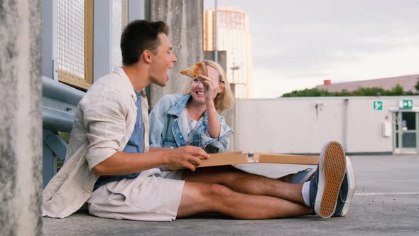 Happy Couple Eating Pizza on City Street