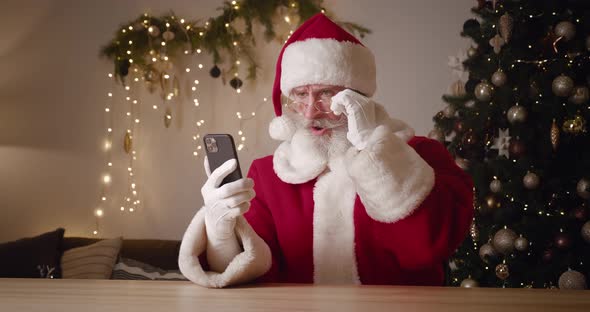 Portrait of a Frustrated Santa Claus Swiping on Websites Browsing Surfing on Internet Web Pages Then