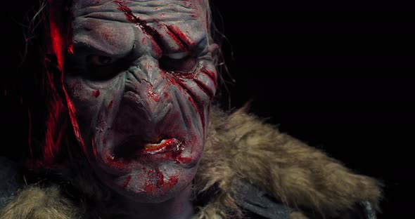 Close Up of a Creepy Orc with Bloody Face, Wearing Fur on His Shoulders, 