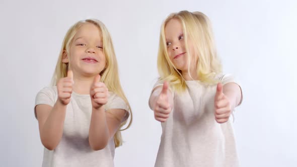 Bubbly Caucasian Twins Showing Thumbs Up