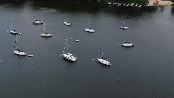 Aerial Arcing Shot of White Sailboats Sitting in Rows, Panoramic Drone Shot