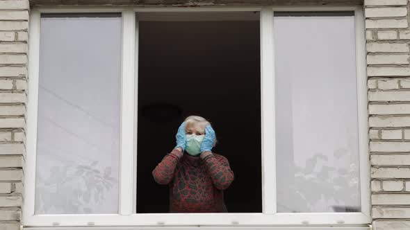 Old Woman Grandmother Stay at Window Isolated at Home on Quarantine. Coronavirus