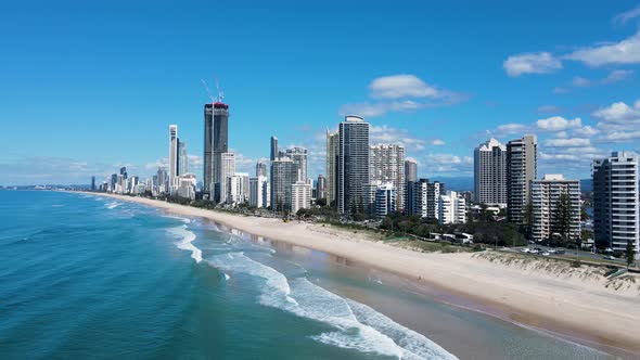 Modern architectural skyline rising above the ocean on a coastal stretch of surf beach at a popular