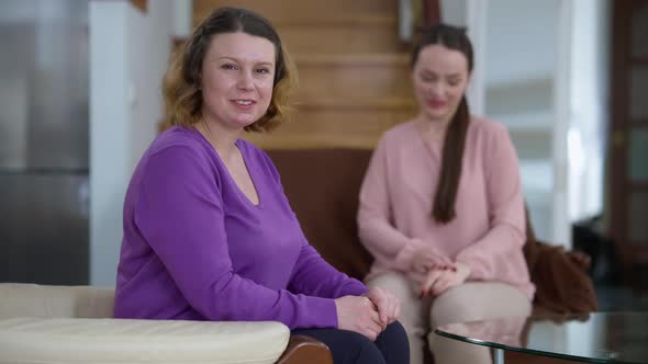 Happy Proud Caucasian Mother Looking at Blurred Daughter at Background Turning to Camera Smiling