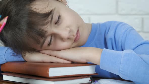 The child sleeps on the books. 