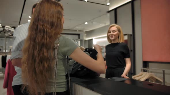 Young Handsome Cashier Seller Taking Customer's Cloth for Packing