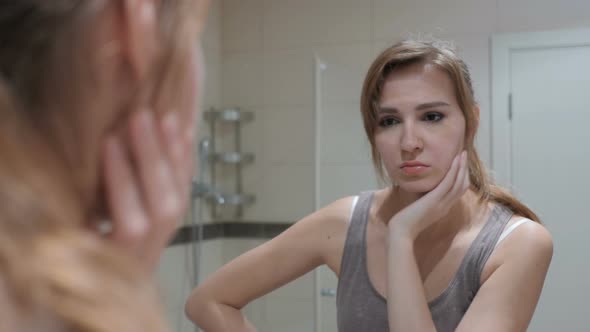 Upset Sad Woman Looking at Herself in Mirror