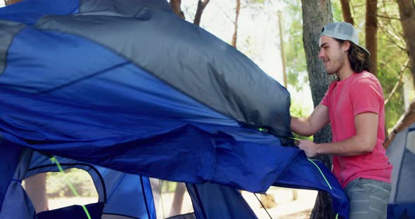 Happy man setting up tent in park 4k