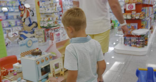 Child is attracted with toy cooker in supermarket