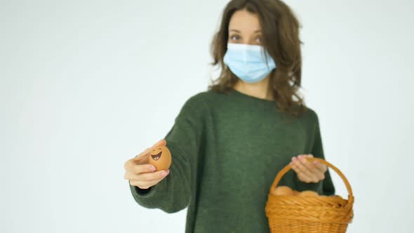 Young Female in Green Sweater and Protective Mask is Showing Hand Drawn Eggs with Anthropomorphic