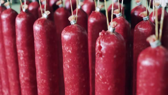 Salami Sausages Are Hanging in a Meat Factory Unit. Storage of Meat Products