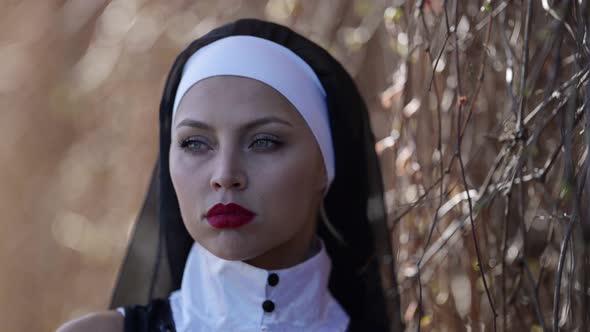 Sexy Woman with Red Lips is Wearing Nun Clothes Portrait at Nature Depraved Righteous Woman