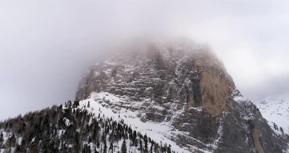 Backward Aerial with Snowy Mountain and Woods Forest at Sella Pass