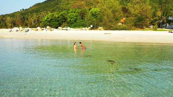 Girls relaxing on beautiful coastline beach lifestyle by blue sea with bright sandy background of Th