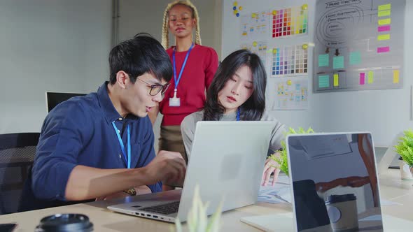 Asian staff creative senior designer coworkers consulting in office on how to solve a problem