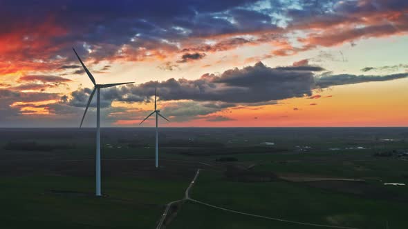 Breathtaking aerial view of wind turbines on field with at dusk