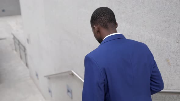 Businessman with laptop bag walking downstairs