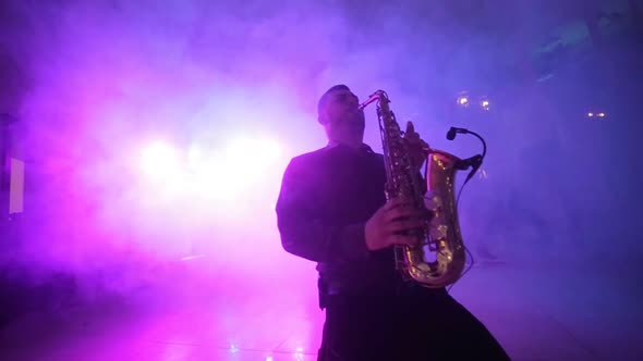 Jazz musician playing the saxophone, music backlit silhouette