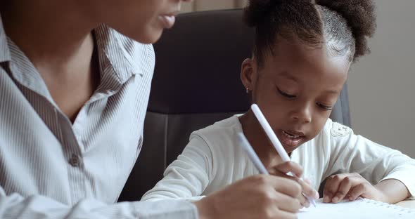 Closeup Little Schoolgirl Black Daughter African American Ethnic Child Sitting at Table with Mom