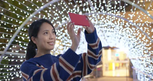 Woman Take Photo on Cellphone with The Beautiful Lighting Decoration in City at Night