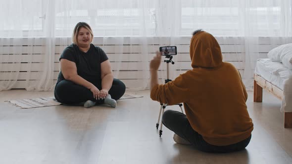 Confident Overweight Woman Feminist and Her Supportive Friend Sitting on the Floor and Recording a