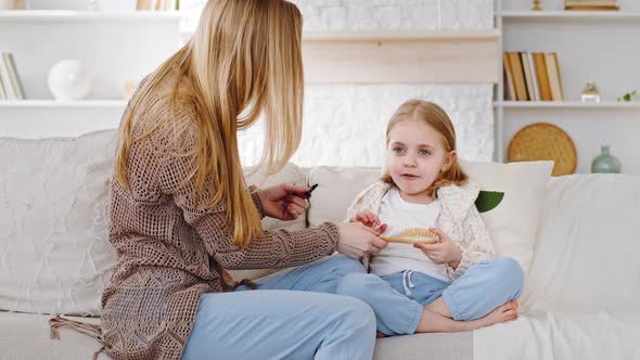 Caucasian Family Caring Mother Babysitter Gives Comb Hairbrush to Little Cute Funny Girl Child