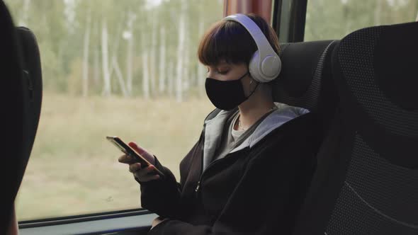 Student Girl in Face Mask Scrolling on Smartphone during Bus Ride