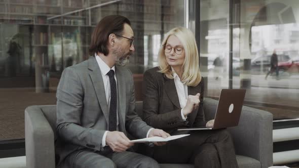 Two Business People Discussing About Work in an Office