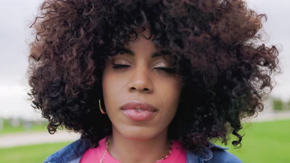 Authentic shot of African american young woman looking at camera outdoor