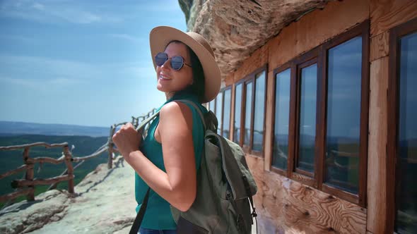 Woman Tourist with Backpack Walking at Observation Deck on Top of Mountain