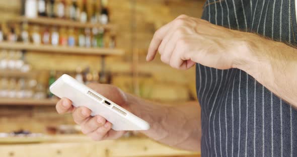 Male Waiter Using Digital Tablet in Cafe 