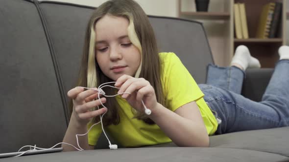 Teenage Girl Untangle Wires From Wired Headphones