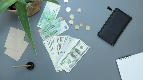 Pile of hundred US dollars banknotes falling on office table