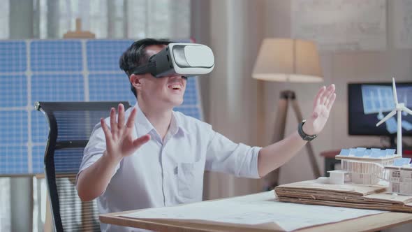 Man Working With A Model Of Small House Roof Solar Panel Wearing Vr And Showing Touching Gesture