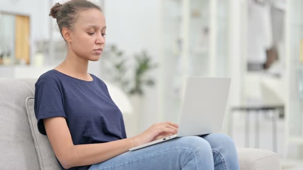 Attractive African Woman with Laptop Looking at Camera in Cafe 