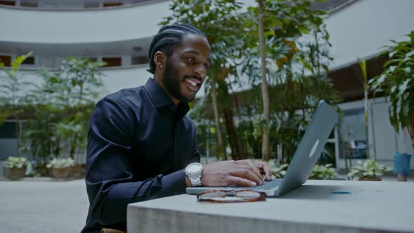 Young AfricanAmerican Businessman Working with a Laptop on the Street