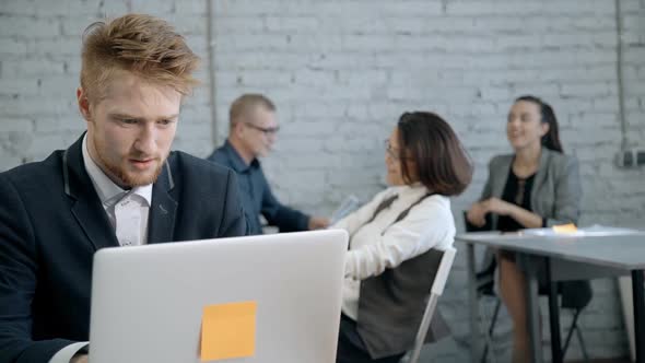 Man Sitting in Meeting Room and Using Laptop