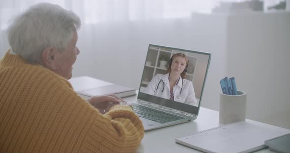 Elderly Sick Man Is Calling By Video Chat To Doctor, Young Female Physician Is Answering To Him and