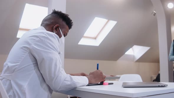 Elderly Woman Comes to a Black Male Doctor Showing Him Her Lung Xrays