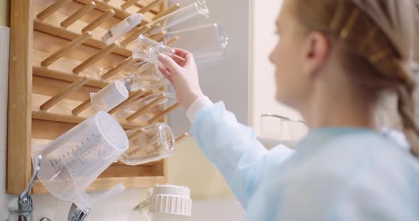Scientist Keeping Beaker On Rack In Laboratory