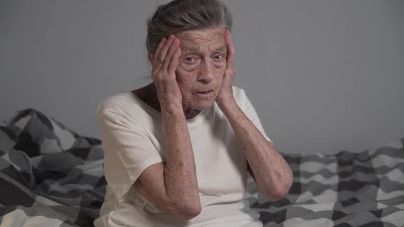 Caucasian Senior Woman with Gray Hair 90 Years Old Holds Her Head Feels Headache and High Blood