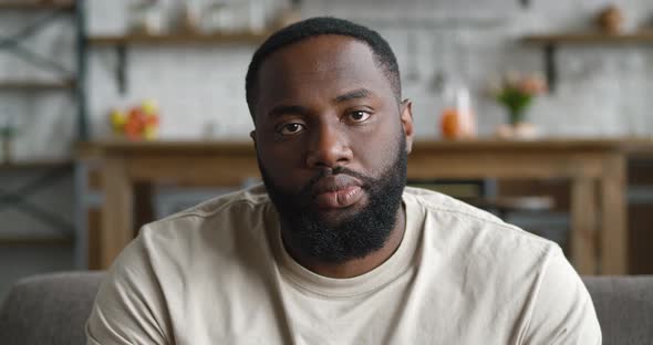 Closeup Portrait of Handsome Young African American Bearded Man Sitting on Sofa at Home in Living