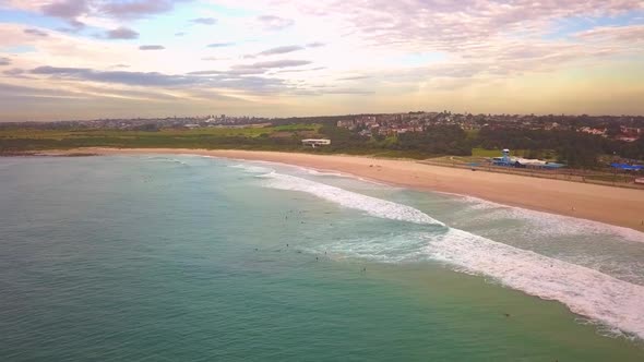 Aerial shot of surfers catching waves, surfing in winter on a windy cloudy morning, Maroubra Beach,