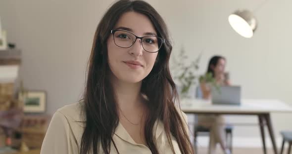 Young Pretty Caucasian Girl in Eyeglasses Looking at Camera and Smiling