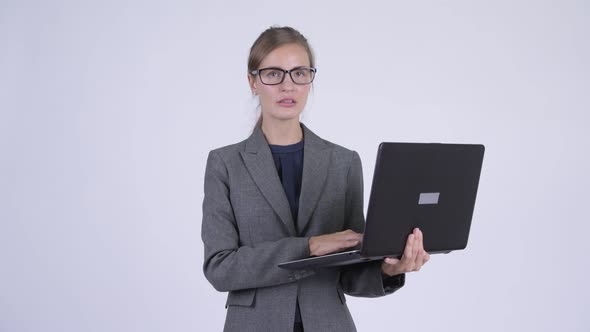 Young Happy Businesswoman Thinking While Using Laptop