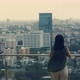 Asian woman using smartphone while standing on the rooftop building. - VideoHive Item for Sale
